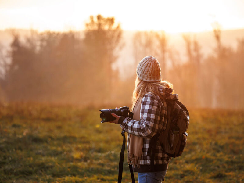 Fotografin in herbstlicher Waldlandschaft