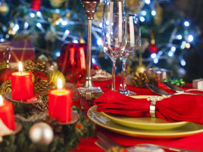 Weihnachtlich geschmückter und gedeckte Tisch mit rot und gelb.