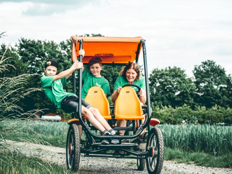 Die Erlebnisbäuering Daniela Mültner und ihre zwei Söhne auf einem Vierrad.